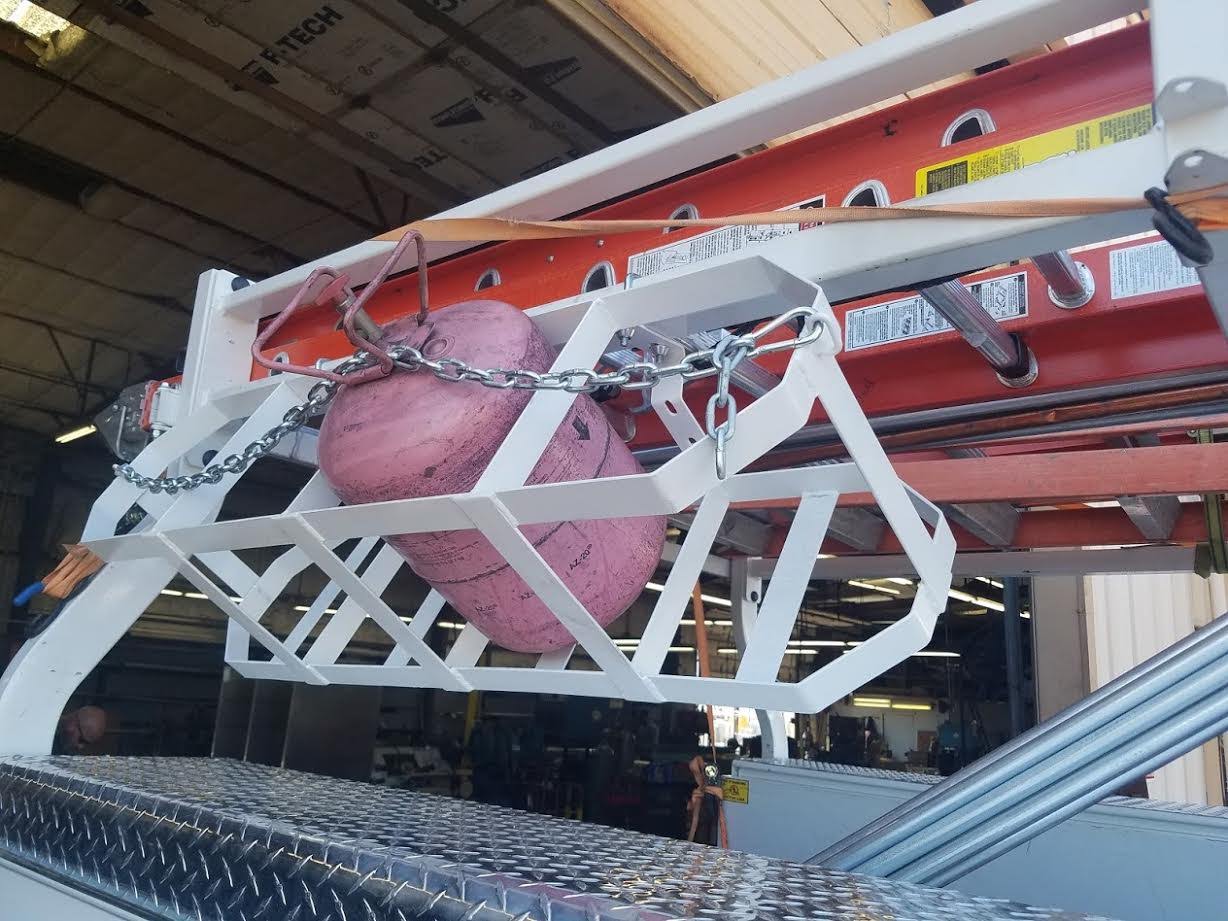 Refrigerant tank storage rack mounted to a commercial truck ladder rack